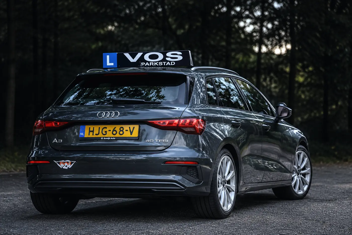 Grijze Audi lesauto van Verkeersschool Vos van achteren