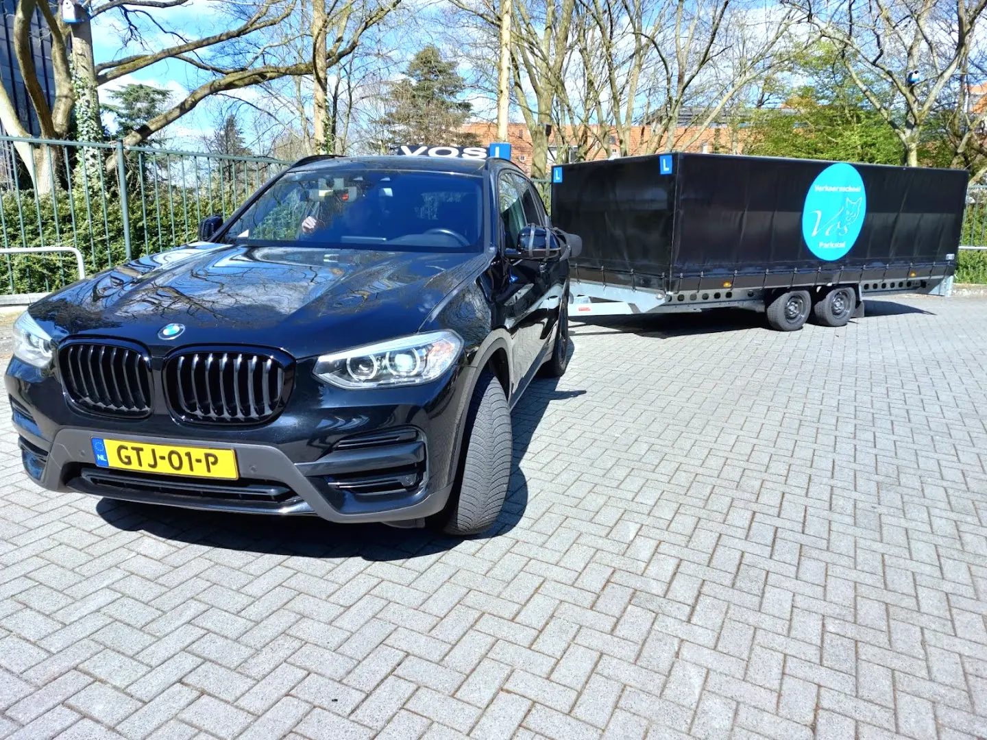 Zwarte BMW met de aanhanger van Verkeersschool Vos